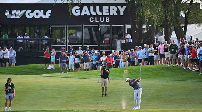 Dustin Johnson hits a shot in front of cameras at the 2022 LIV Golf Chicago event.